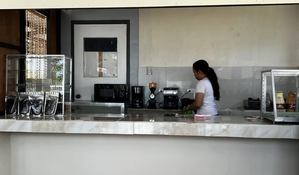 Ung barista i arbeid ved kaffemaskinen.