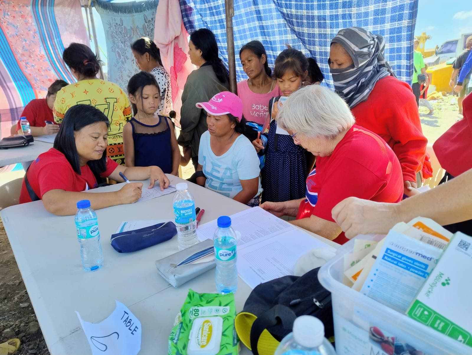 Helsepersonell fra sykehuset undersøker pasienter under en medical mission i slummen.